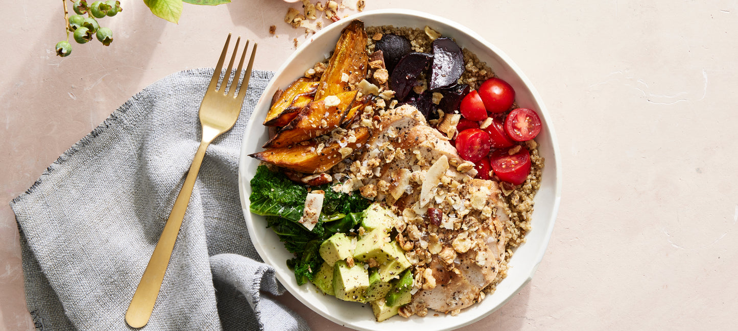 A colorful bowl of veggies, chicken and nutrient-dense Struesli sprinkled on top.