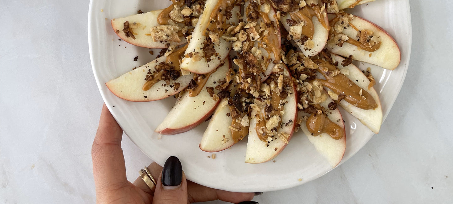 Apple slices topped with nut butter and struesli's organic granola.