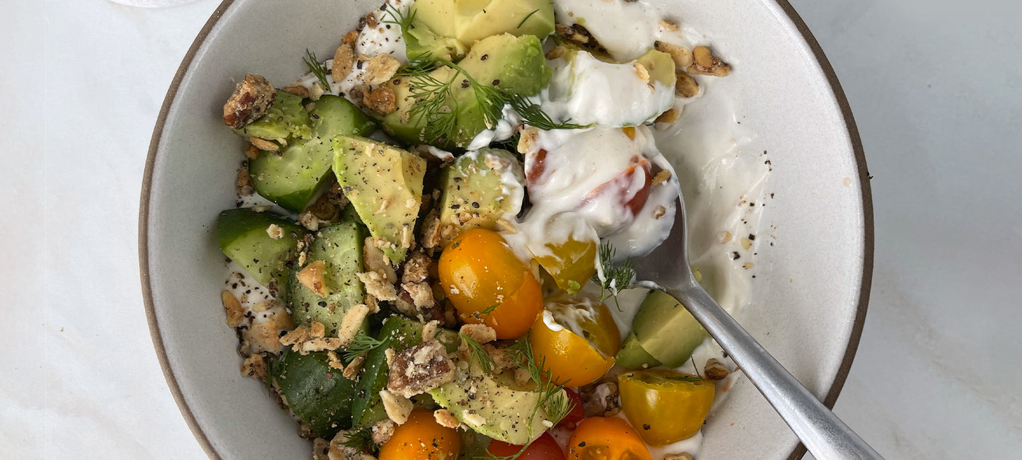A savory yogurt bowl with avocado, tomatoes and Struesli's organic granola.