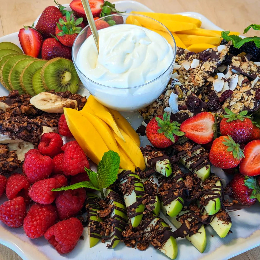A colorful fruit platter with chocolate and Struesli's organic granola.