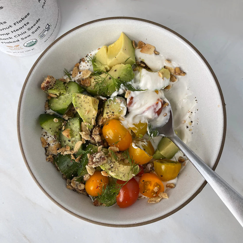 A savory bowl of yogurt topped with tomatoes, avocado and Struesli's organic granola.