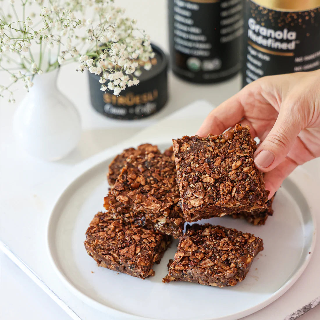 Crunchy breakfast bars stacked on a plate, made using Struesli's cacao + coffee granola.