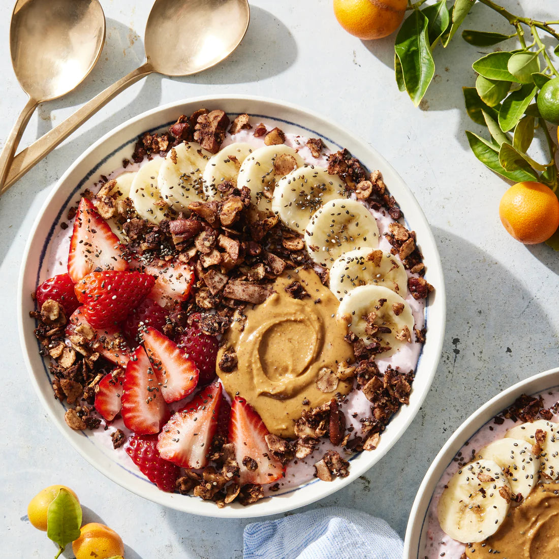 A yogurt bowl topped with strawberries, nut butter and rich Struesli cacao + coffee granola.