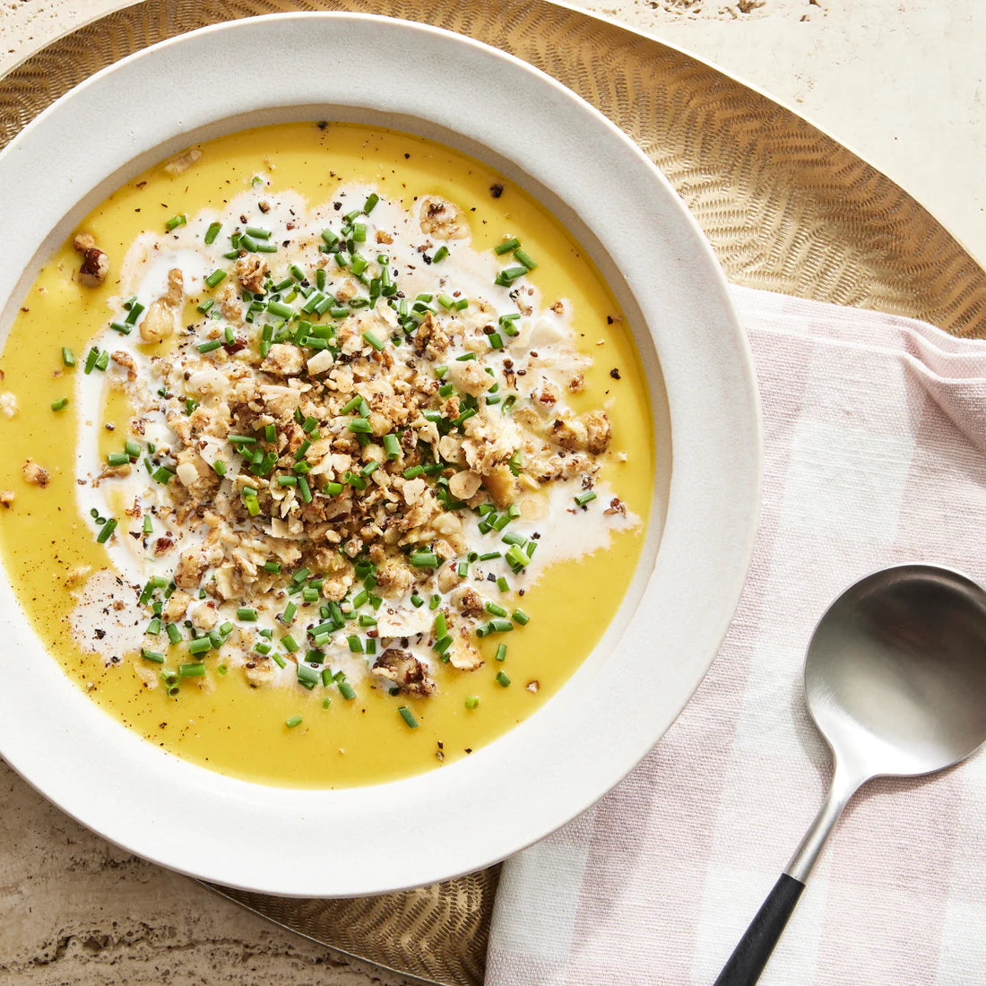 A comforting bowl of curried butternut squash bisque topped with Struesli granola.