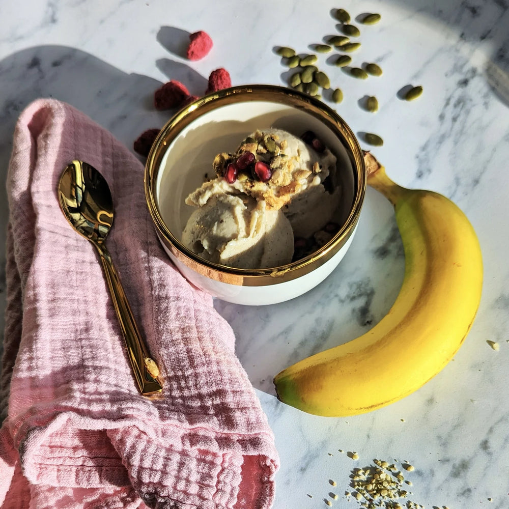 A bowl of dairy-free banana ice cream topped with nut-free Struesli savory + seed granola.