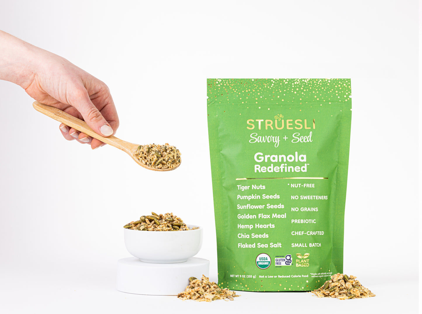 A package of Struesli Savory + Seed granola next to a bowl and spoonful of granola