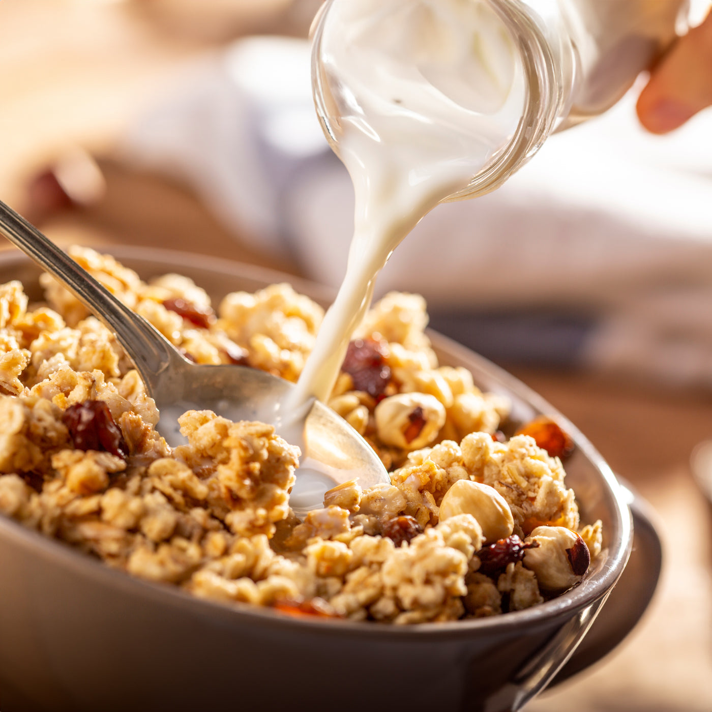Milk being poured over a bowl of generic granola