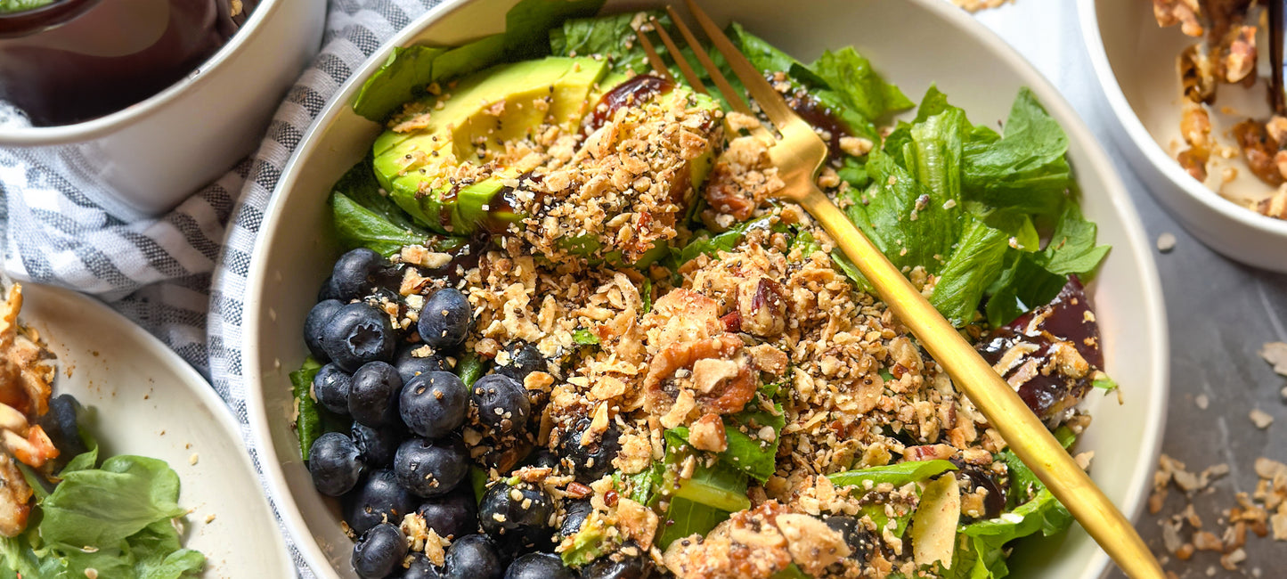 A bowl of summer crunch salad with blueberries, avocado and Struesli's organic granola.