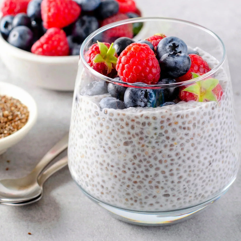 A Chia Pudding Topped With Fruit Next To a Bowl of Chia Seeds