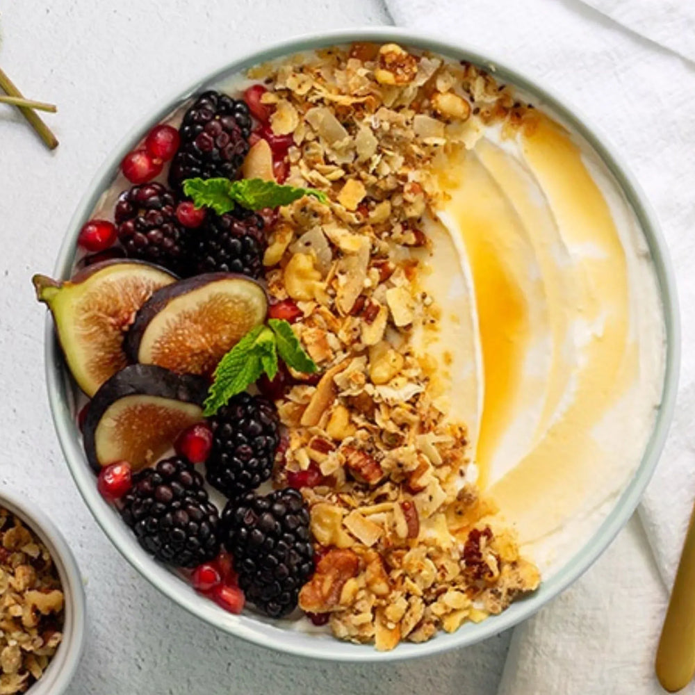 A bowl of yogurt topped with Struesli Original granola and figs