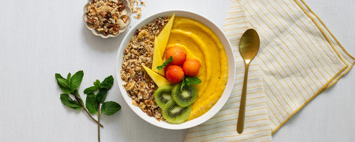 Vibrant Mango Smoothie Bowl Topped With Fruit and Struesli Granola
