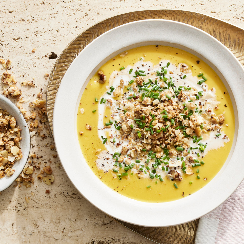 A comforting bowl of curried butternut squash bisque topped with Struesli granola for satisfying crunch.
