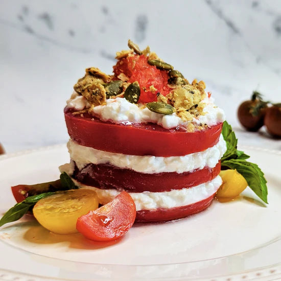 Chilled tomato stack with cottage cheese, a drizzle of olive oil, basil and granola.