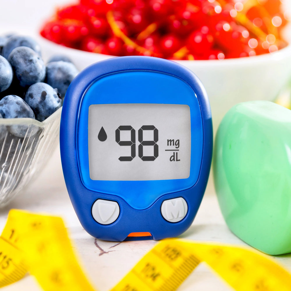 A glucose monitor next to some vibrant berries.