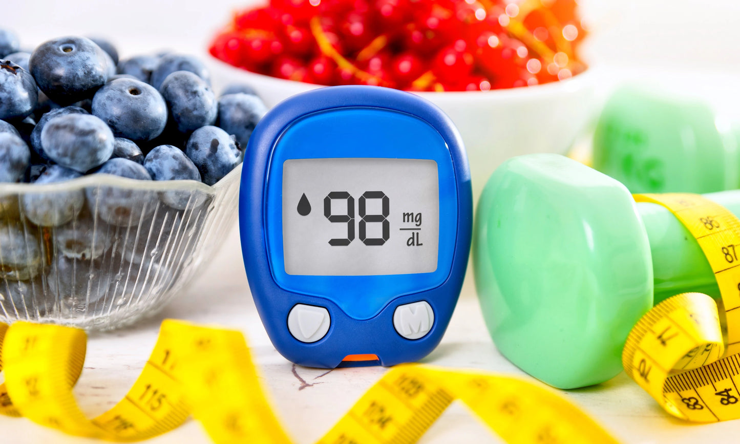 A glucose monitor next to some vibrant berries.