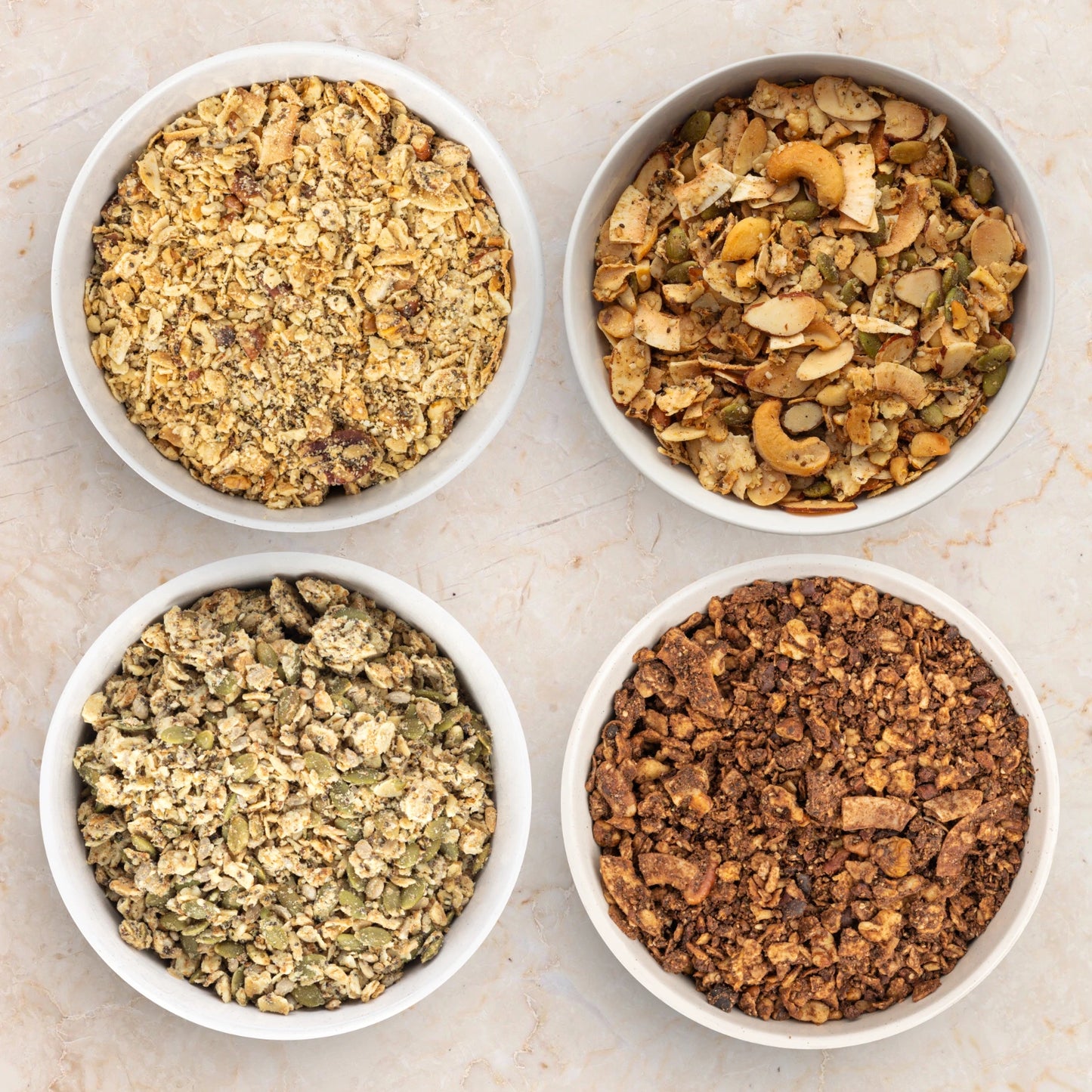 Four bowls of granola: Struesli Original, Struesli Savory & Seed, Struesli Cashew & Vanilla, Struesli Cacao & Coffee