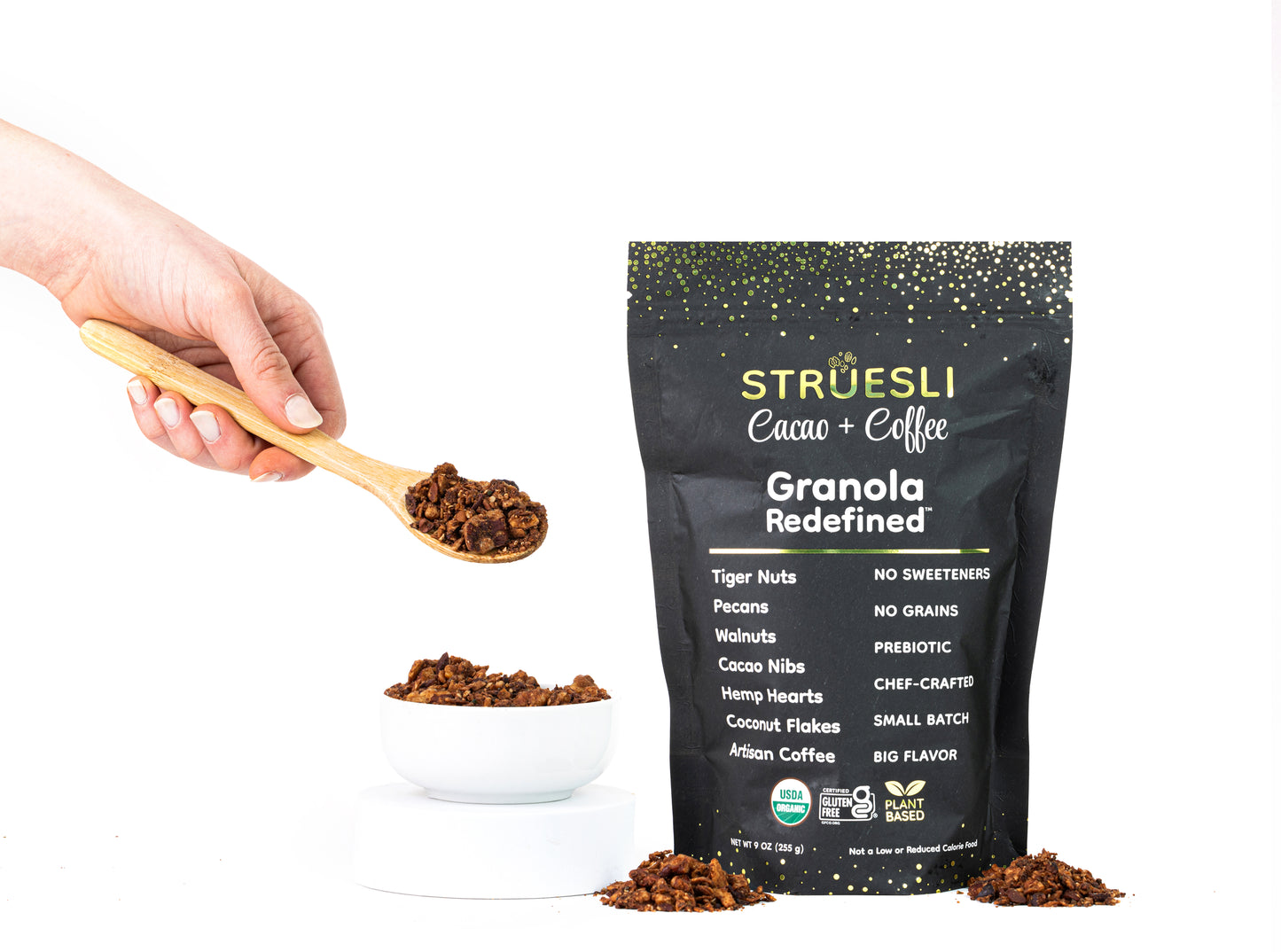 A package of Struesli Cacao + Coffee granola next to a bowl and spoonful of granola